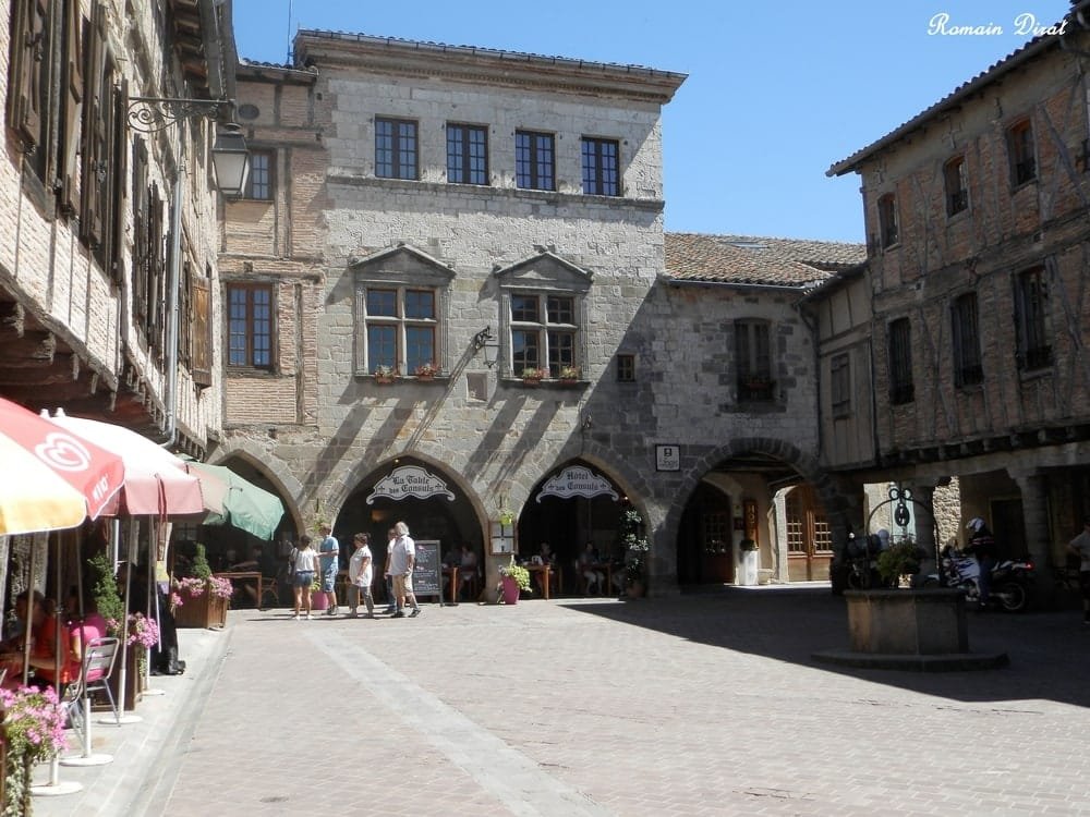 Place centrale de Castelnau-de-Montmiral avec des maisons à colombages